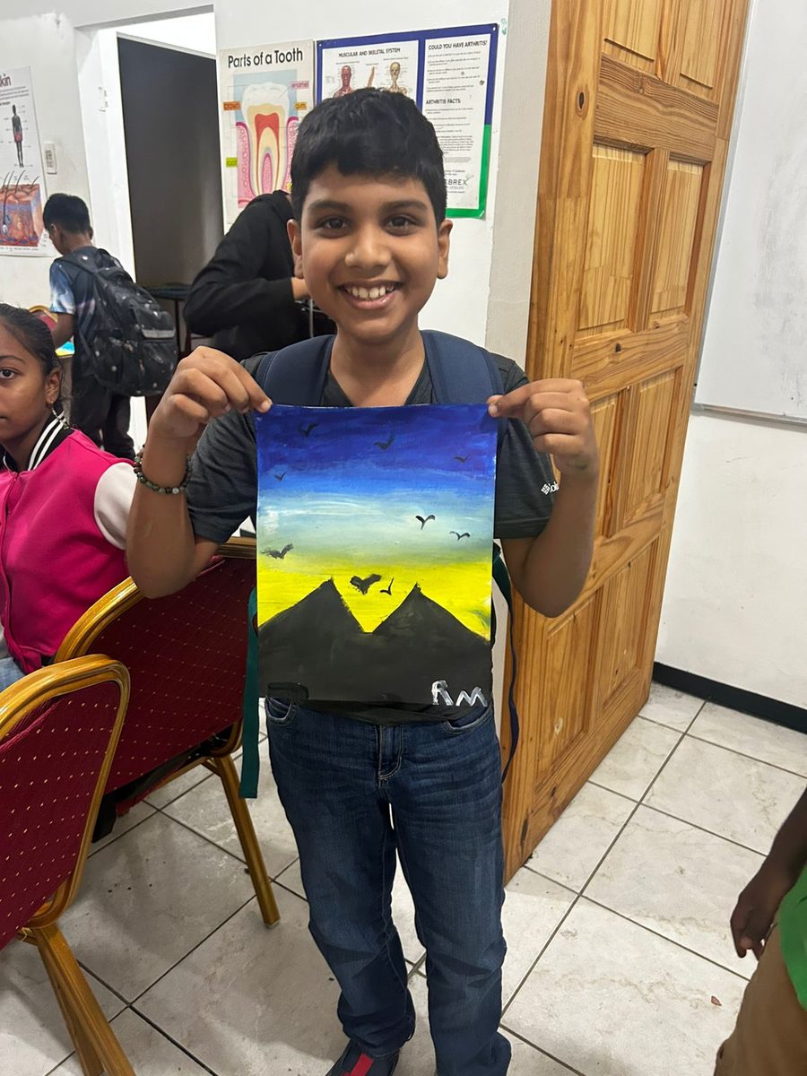 Student proudly displaying his painting